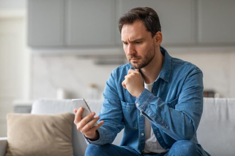 Un homme préoccupé lit son smartphone